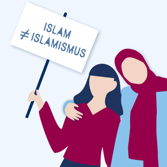 Eine Person mit langen Haaren hält ein Schild hoch mit der Aufschrift "Islam ungleich Islamismus". Neben ihr steht eine Person mit Kopftuch, die einen Arm um ihre Schultern legt.
