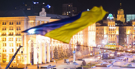 Blick auf Euromaidan in Kiew mit der ukrainischen Fahne im Vordergrund