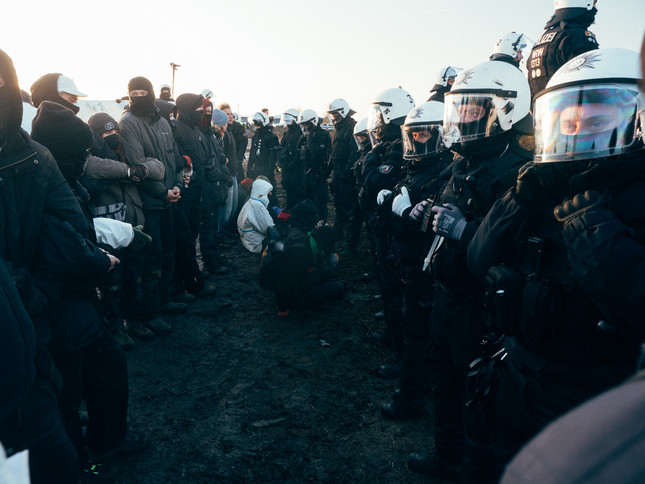 Polizeikette steht bei der Räumung von Lützerath einer Kette von Protestierenden gegenüber