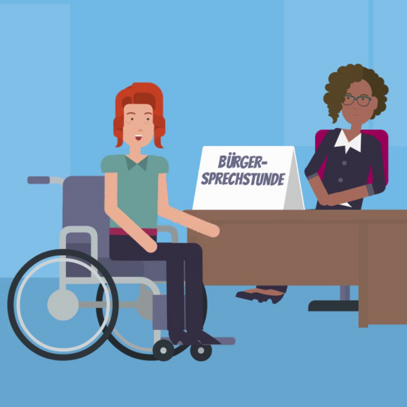 Eine Person mit Rollstuhl unterhält sich mit einer anderen Person, die an einem Schreibtisch sitzt. Auf dem Schreibtisch steht ein Schild mit der Aufschrift "Bürgersprechstunde".