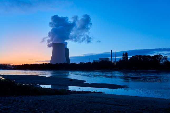 Ein Atomkraftwerk an einem Fluss bei Sonnenuntergang