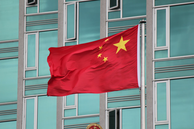 Chinesische Flagge weht vor Bürogebäude