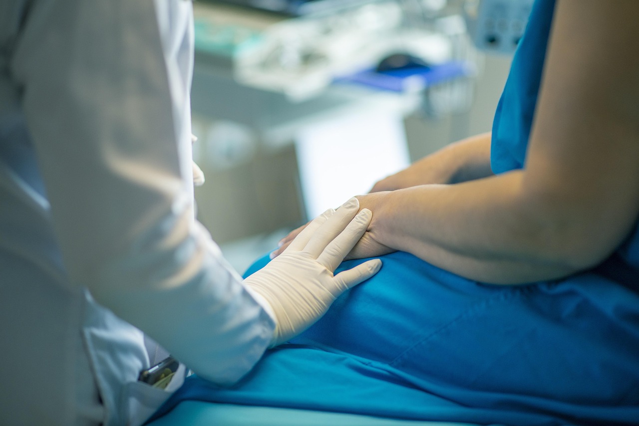 Hand in medizinischem Schutzhandschuh berührt Hand einer Patientin